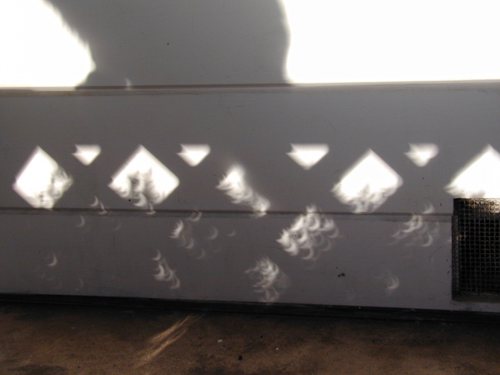 this is close up of thge solar eclipse as the sunlight penetrated the lattice work